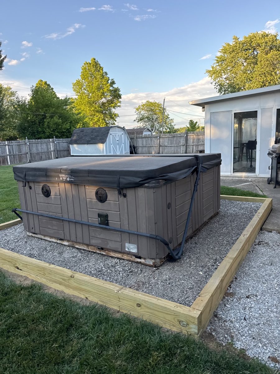 Hot tub set level on its new gravel pad behind the house