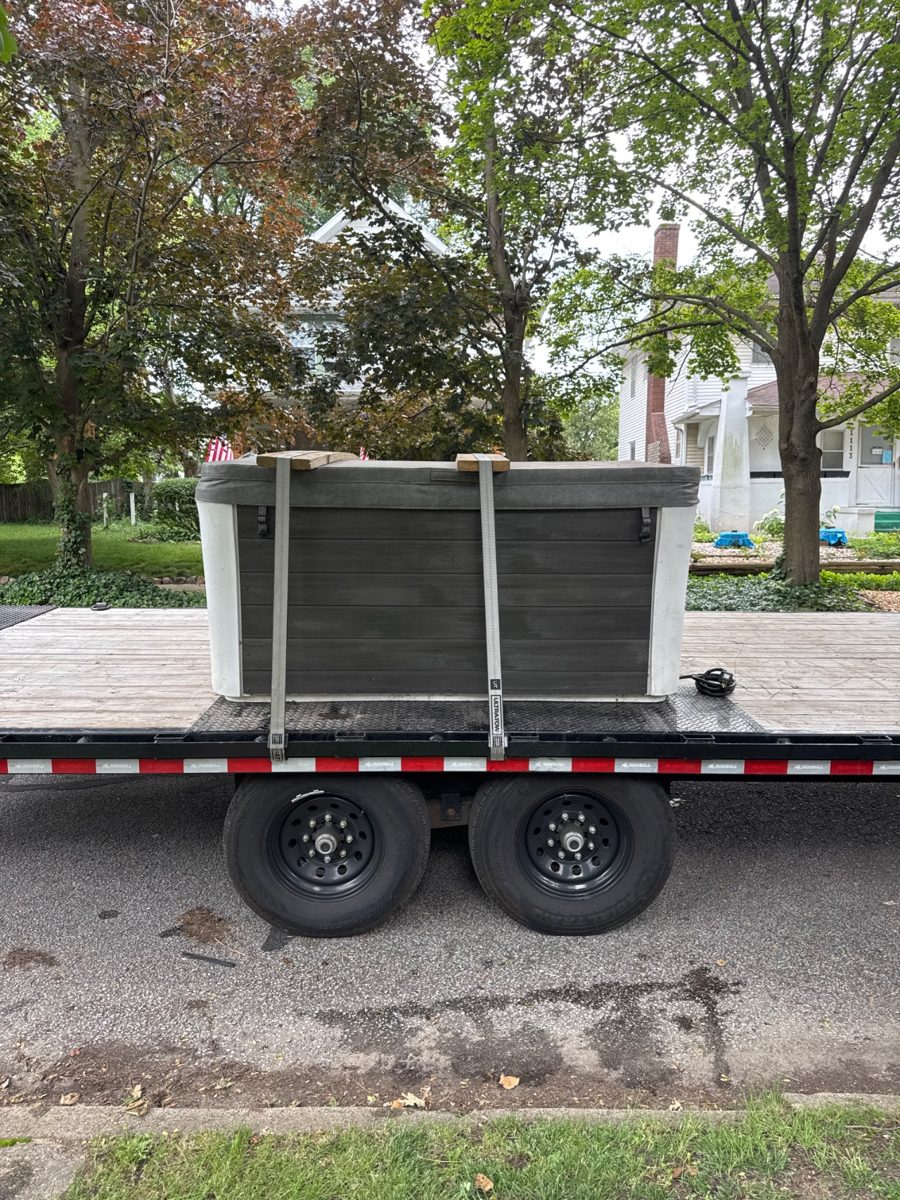 Hot tub strapped down on our flatbed trailer at the curb