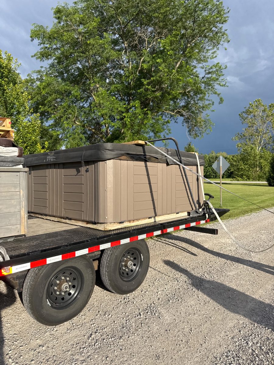 Hot tub on the trailer ready to roll under a storm sky