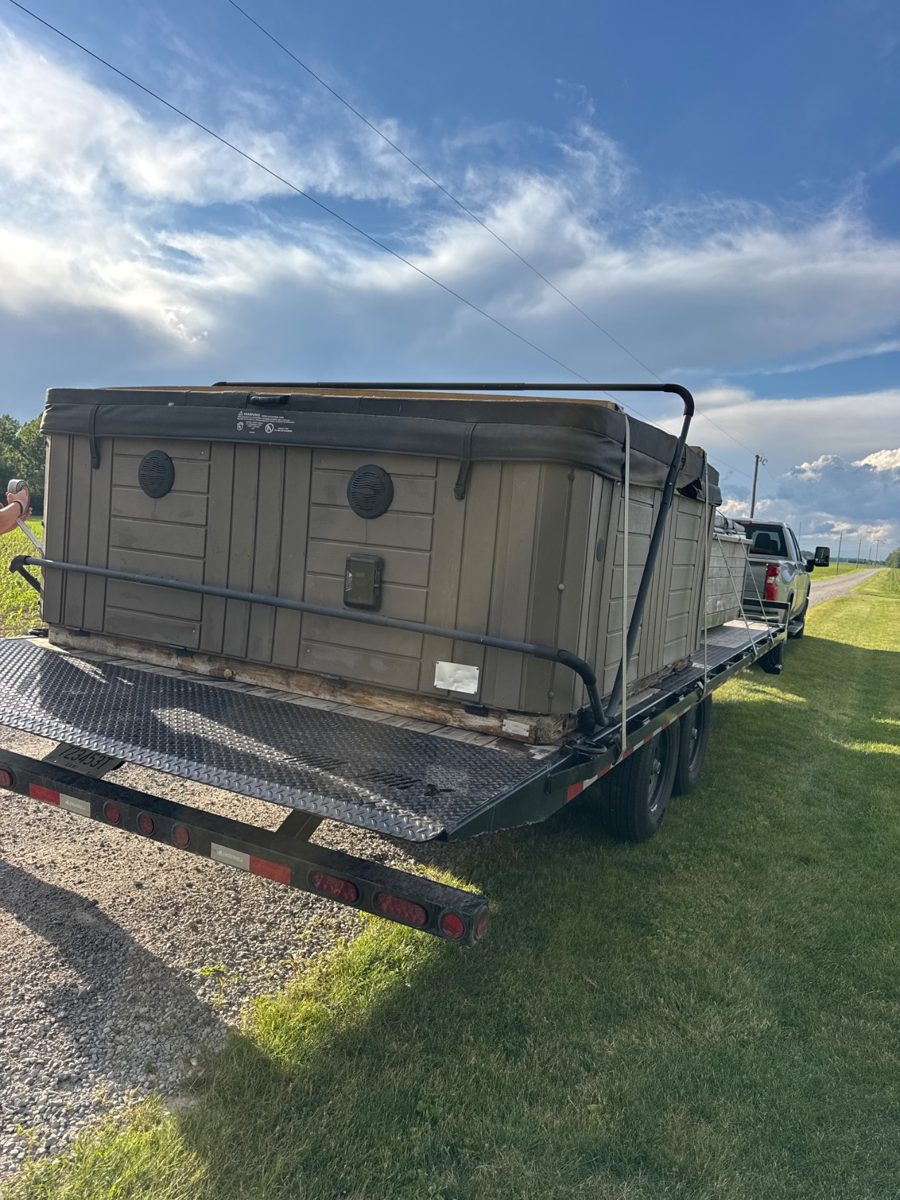 Hot tub tied down on the trailer in a customer driveway